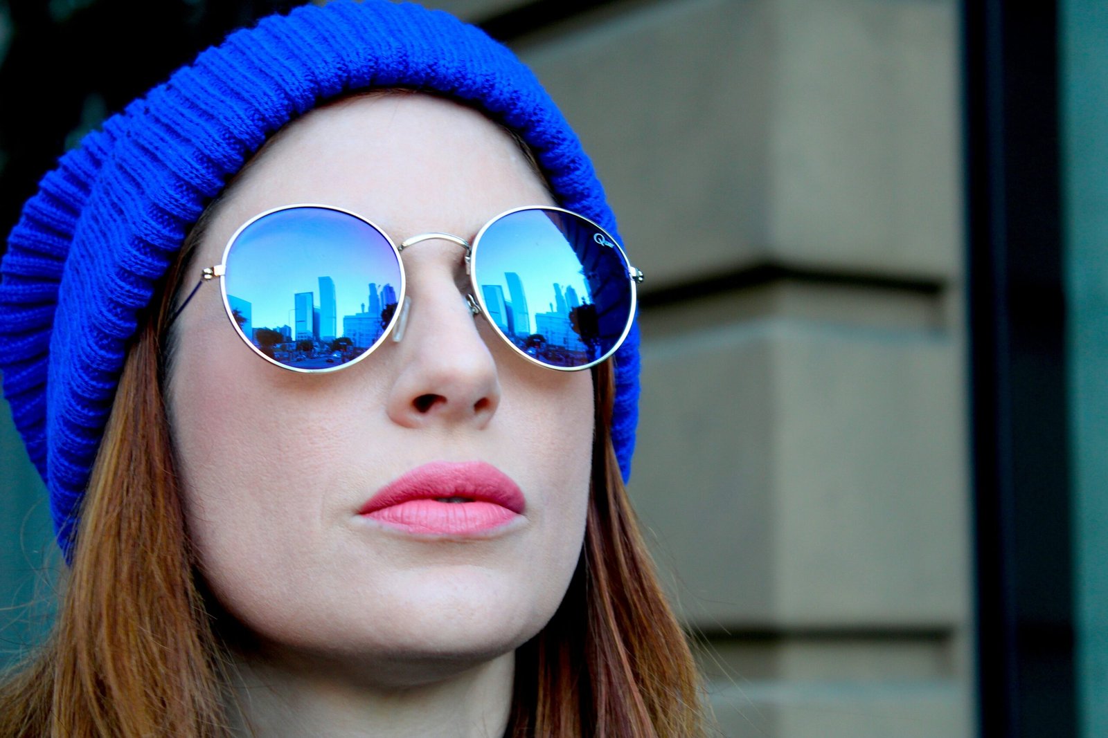 woman in blue knit cap wearing blue sunglasses